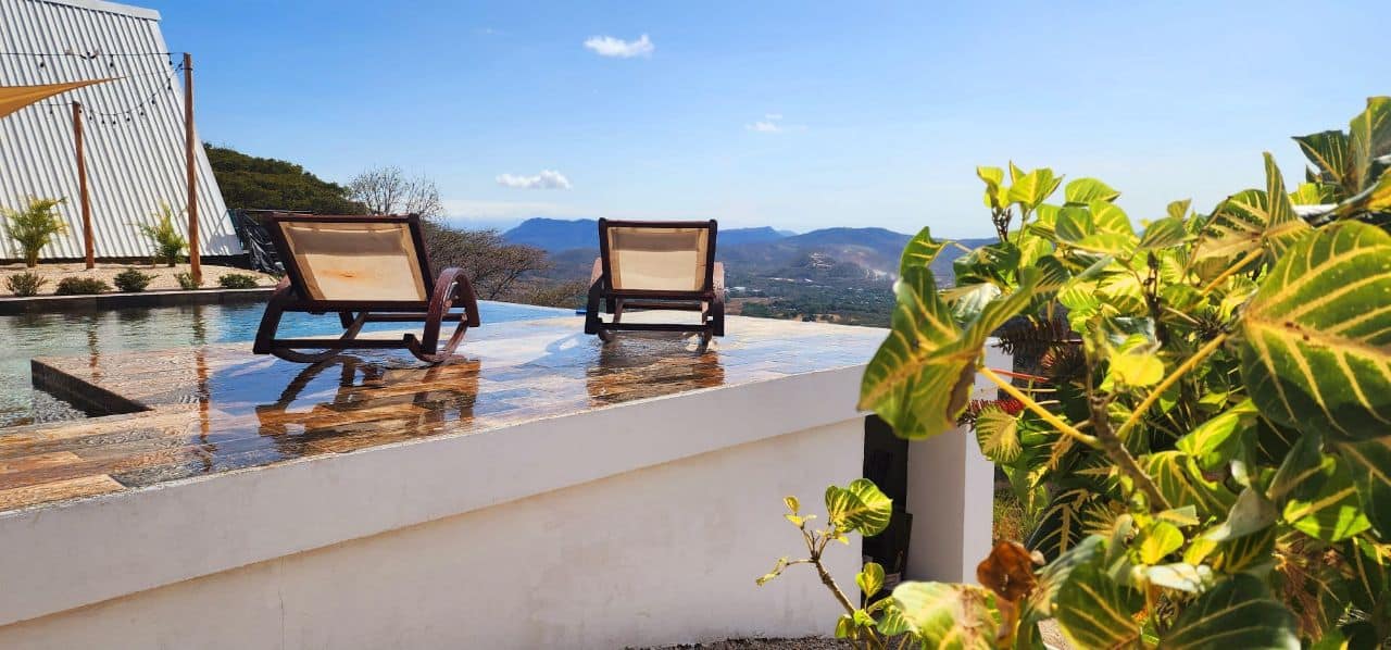 Deck chair on the Bluesky Lodge terrace facing the Nicoya mountains under a clear blue sky
