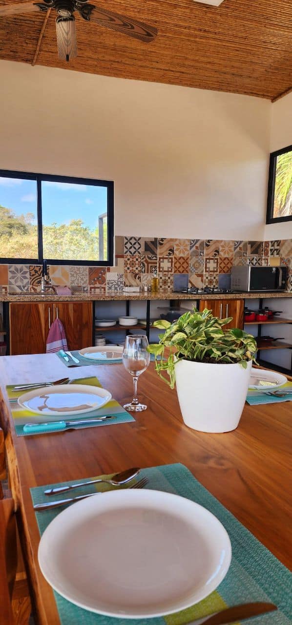 Modern kitchen with decorative tiles and dining area with prepared table, perfect for an exclusive stay