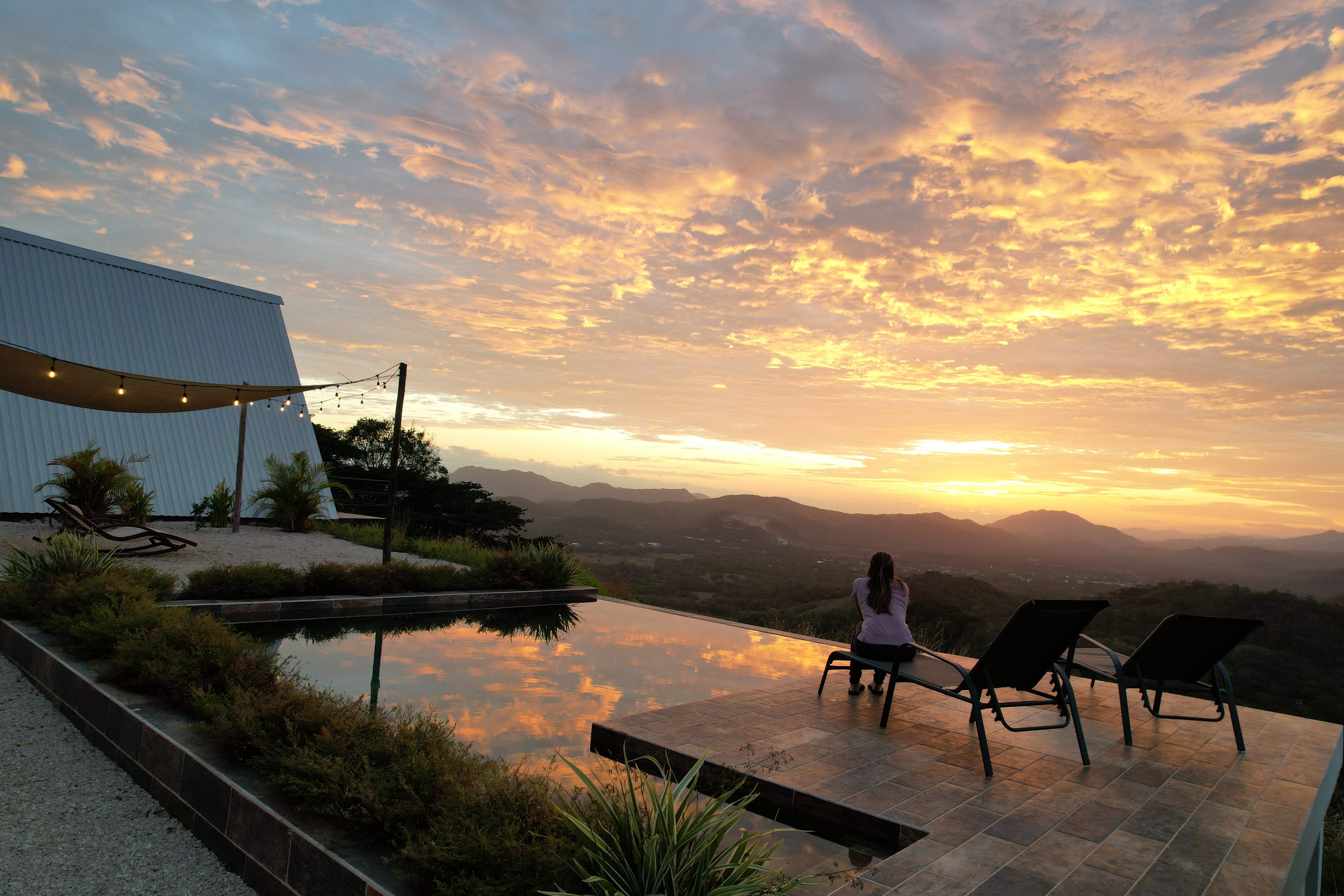 Person enjoying sunrise at the infinity pool with panoramic view, an upscale Costa Rica experience