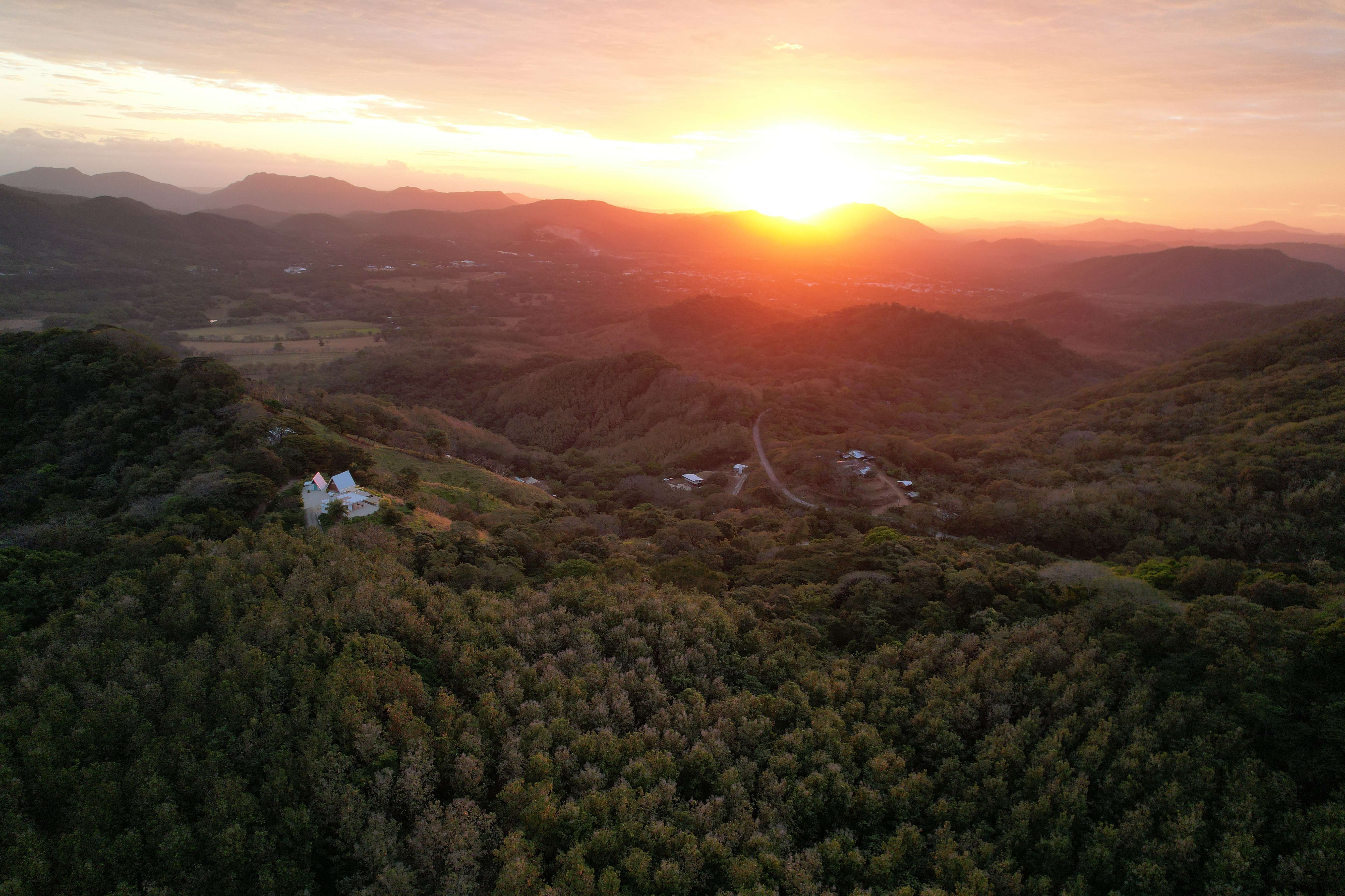 Wide aerial view of the upscale lodge during golden hour with stunning mountainous landscape